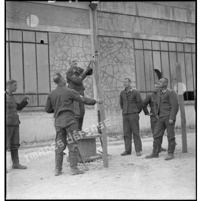 Photographie de groupe d'aviateurs allemands qui mettent en place des barbelés dans un camp de prisonniers du secteur de la 2e armée.