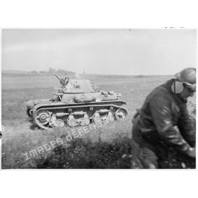 Un char Renault R35 est photographié en plan général de profil alors qu'il se déplace dans un champ.