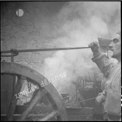 Des maréchaux-ferrants de la 42e DI travaillent sur une forge roulante d'artillerie modèle 1876-1897.