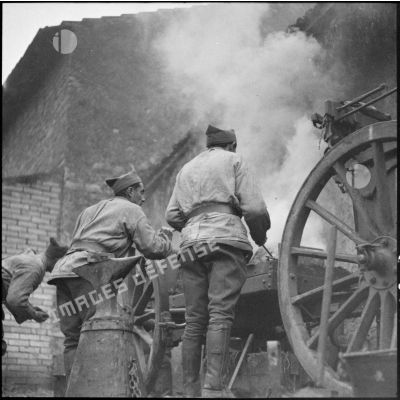 Des maréchaux-ferrants de la 42e DI travaillent sur une forge roulante d'artillerie modèle 1876-1897.