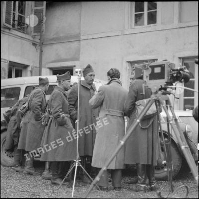 Photographie de groupe de soldats de la 3e armée près d'un micro et d'une caméra du SCA.