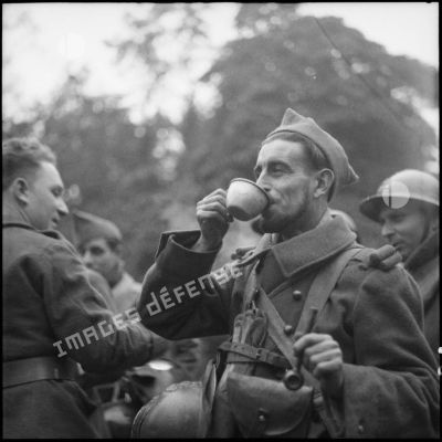 Photographie de groupe de fantassins de la 3e armée qui boivent.