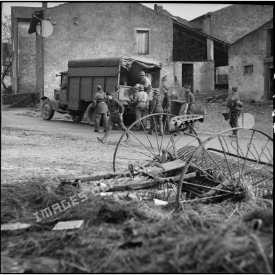 Dans un village de Moselle des soldats déchargent un camion.