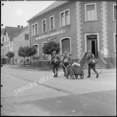Des cavaliers du 11e GRCA se déplacent à pied dans une rue de Lauterbach.