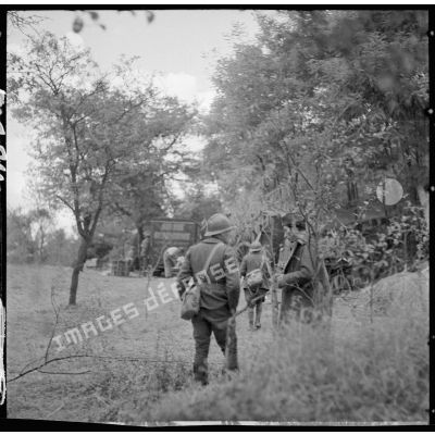 Des soldats de la 3e armée se tiennent à l'orée d'un bois, des voitures hippomobiles sont visibles.