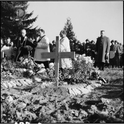 Dans un cimetière un prêtre catholique officie lors de l'enterrement de soldats de la 3e armée.