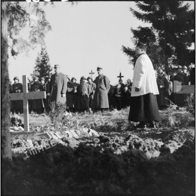 Dans un cimetière un prêtre catholique officie lors de l'enterrement de soldats de la 3e armée.