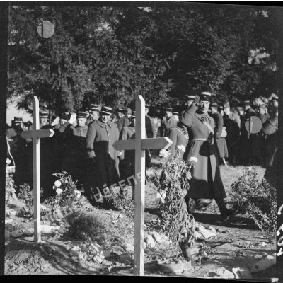 Officiers et soldats défilant devant les tombes de soldats de la 3e armée en saluant.