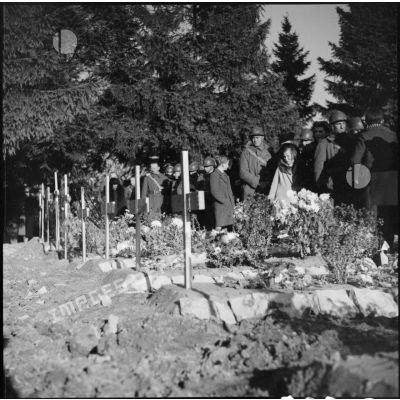 Officiers et soldats défilant devant les tombes de soldats de la 3e armée en saluant.