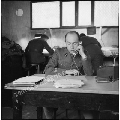 Portrait d'un capitaine de la 3e armée qui répond au téléphone à son bureau.