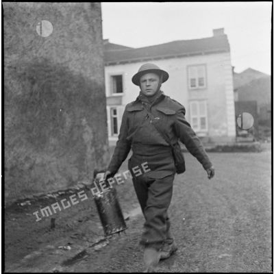 Un soldat de la 51e DI (BEF) est photographié en plan américain dans un village de Moselle (zone de la 3e armée).