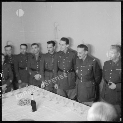 Lors d'un pot dans une pièce, photographie de groupe du général Condé, commandant la 3e armée, entouré d'officiers.