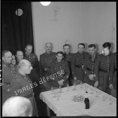 Lors d'un pot dans une pièce, photographie de groupe du général Condé, commandant la 3e armée, entouré d'officiers.