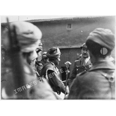 Des soldats de la 3e armée originaires d'Afrique du nord entourent un micro dans un village de Moselle.