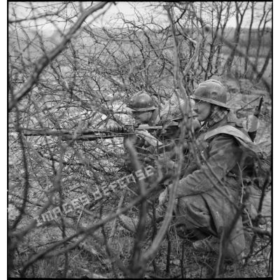 Deux soldats servent une mitrailleuse Hotchkiss 8 mm M1914 dans une forêt du secteur de la 3e armée.