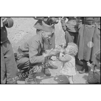 Un soldat de la 3e armée donne à boire à une enfant.