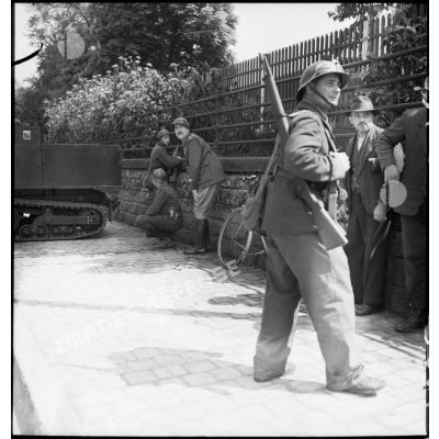 Dans une rue de Esch-sur-Alzette des soldats de la 3e DLC sont postés derrière un muret.