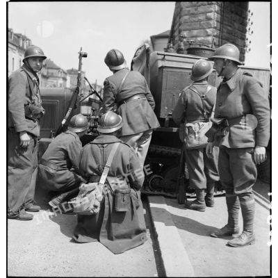 Des soldats de la 3e DLC se tiennent postés derrière un semi-chenillé dans une rue de Esch-sur-Alzette.