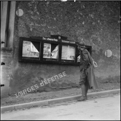 Un soldat de la 42e DI est photographié en pied dans une rue de Lauterbach.