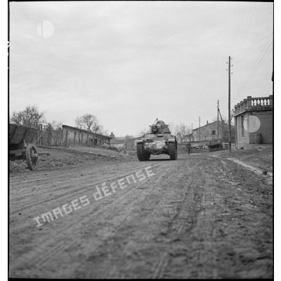 Un char Renault R35 du 5e BCC roule dans une rue d'un village de Moselle.