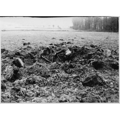 Un soldat de la 4e armée se tient posté dans un trou d'obus au milieu d'un champ.