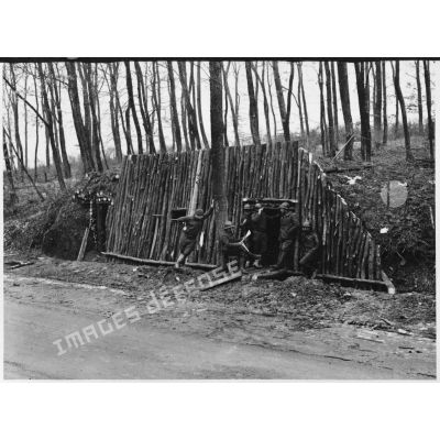 Des soldats de la 4e armée se tiennent devant un abri fortifié de rondins de bois.