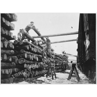 Des soldats de la 4e armée chargent des rondins de bois dans des wagons.