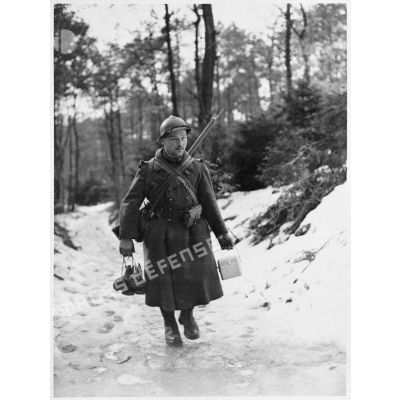 Portrait en pied d'un soldat de la 4e armée qui marche dans la neige.
