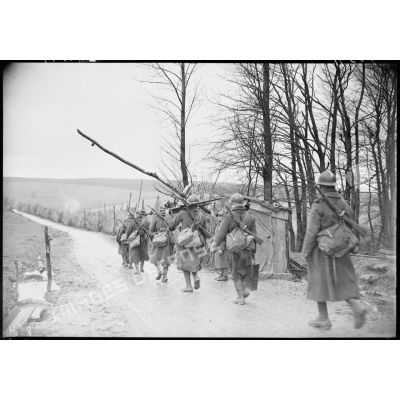 Des fantassins d'une section de mitrailleuses marchent sur une route dans le secteur de la 4e armée.