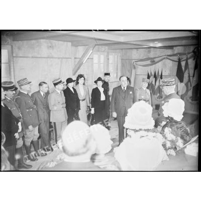 Photographie de groupe de personnalités politiques et militaires lors d'une visite dans un foyer de la 4e armée.