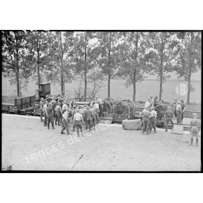 Sur le quai d'une gare dans le secteur de la 4e armée, chargement de 75 mm modèle 1897 sur un train.