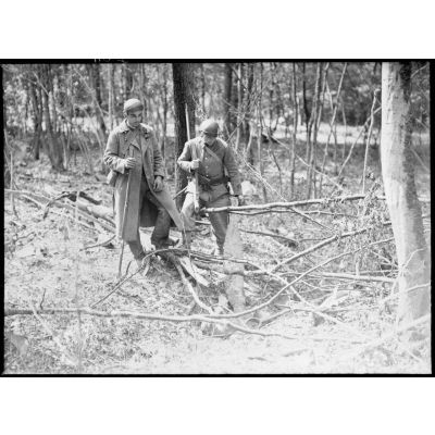 Deux artilleurs, appartenant probablement au 403e régiment d'artillerie antiaérienne (RAAA), inspectent les débris d'un avion allemand abattu.