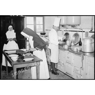 Soldats de la 4e armée et religieuses qui travaillent dans les cuisines d'un établissement religieux.