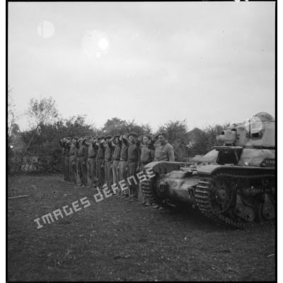 Des soldats de la 4e armée saluent près d'un char Renault R35.