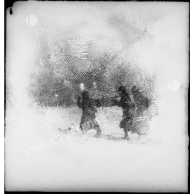 Des soldats de la 4e armée portent un panier de pains dans la neige lors d'une corvée.