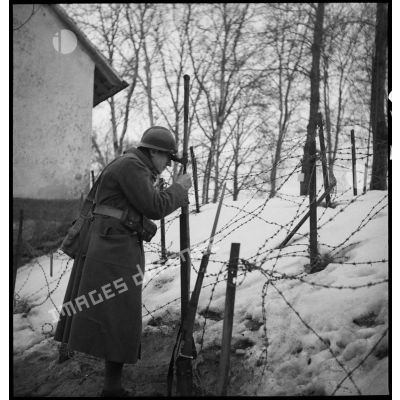 Une sentinelle de la 5e armée est photographiée près de barbelés enneigés.