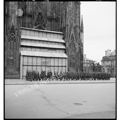 Des soldats de la 5e armée se déplacent en ordre serré devant le parvis de la cathédrale de Strasbourg.