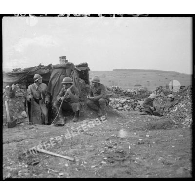 Des soldats de la 5e armée sont photographiés près d'un abri, des tranchées sont visibles.