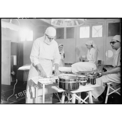 Dans la salle d'opérations d'un hôpital militaire un chirurgien est secondé par des infirmières britanniques de la Formation Hadfield Spears.