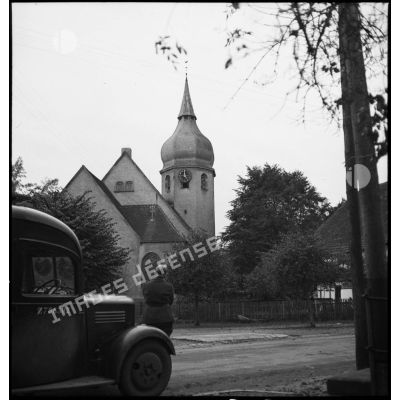 Un caméraman du service cinématographique de l'armée (SCA) filme l'église protestante de Sessenheim (Bas-Rhin).