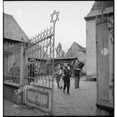 Devant une synagogue un aumônier militaire de confession juive évacue les tables de la Loi aidé de gendarmes.
