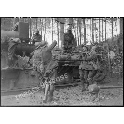 Des servants de la 5e armée manipulent un obus afin d'approvisionner la pièce de 220 mm long M1917.
