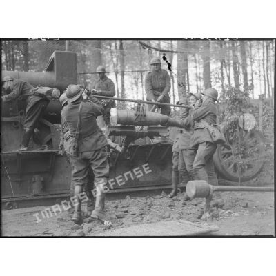 Des servants de la 5e armée manipulent un obus afin d'approvisionner la pièce de 220 mm long M1917.
