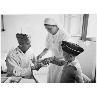 Un médecin militaire et une infirmière soignent un enfant dans un hôpital du secteur de la 5e armée.