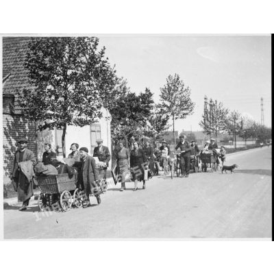 Un groupe de réfugiés marchent sur une route du Bas-Rhin dans le secteur de la 5e armée.
