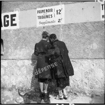Deux femmes sont photographiées de dos à l'entrée du stade d'Antibes.