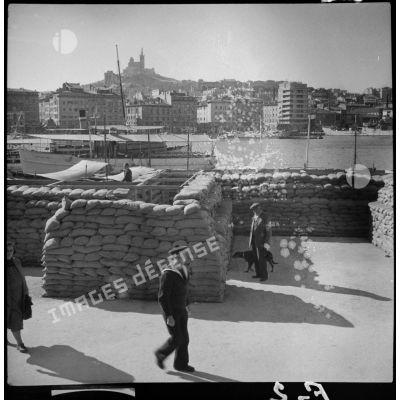 Plan général du vieux port de Marseille avec au premier plan des sacs de sable en protection.