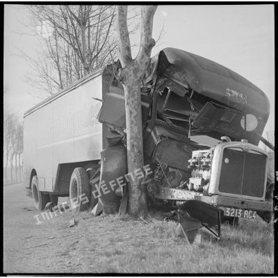 Plan moyen d'un poids lourd civil écrasé contre un arbre sur une route du secteur de la 6e armée.