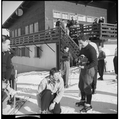 Un caméraman du SCA discute avec un chasseur du 199e BCHM qui chausse ses skis.