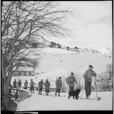 A skis, des éclaireurs-skieurs de la 6e armée se déplacent en colonne dans un paysage enneigé.
